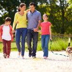 Hispanic Family Taking Dog For Walk In Countryside