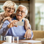 Happy mature couple using mobile phone and having fun while taking selfie.