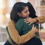 Cropped shot of two young women embracing each other at home