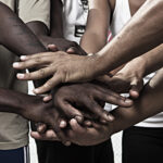 Closeup portrait of group with mixed race people with hands together