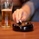 close up of man smoking cigarette at bar