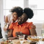 Smiling multiethnic friends socializing  while having a meal together.