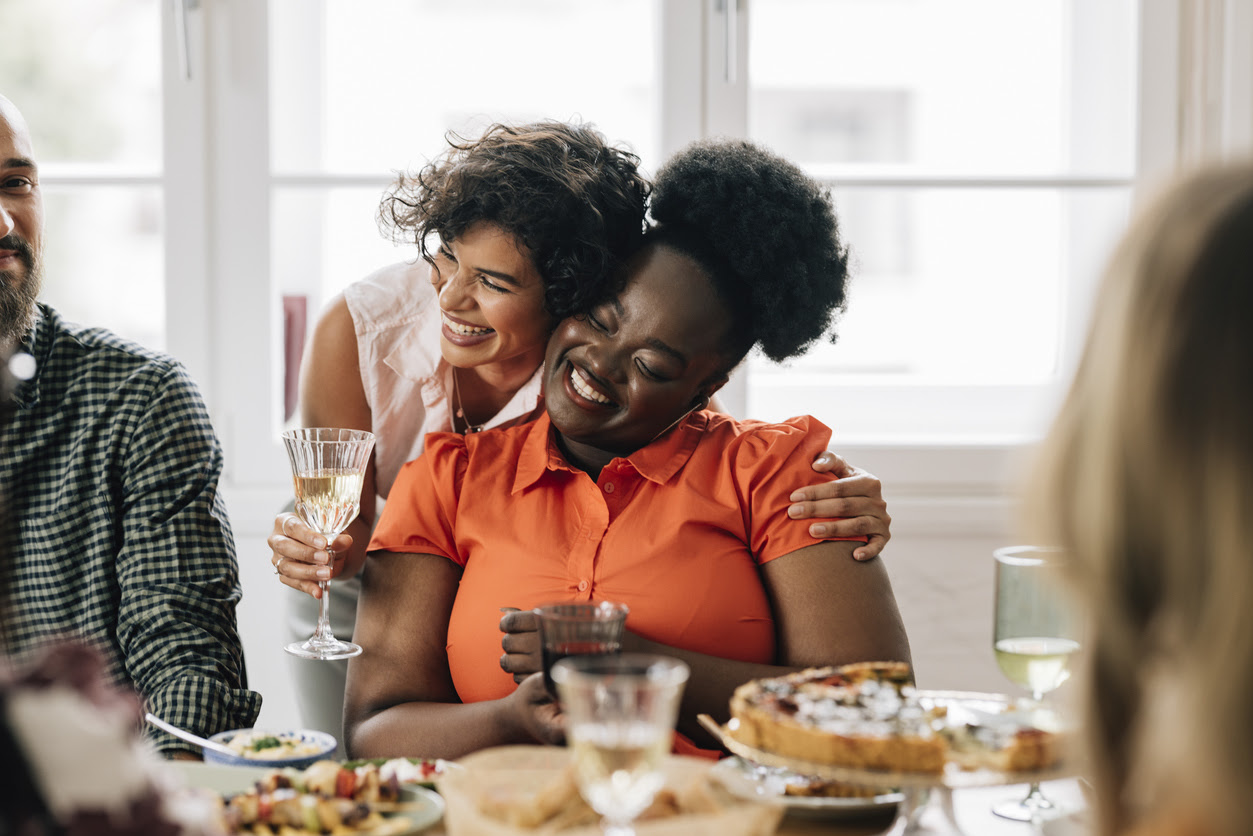 Smiling multiethnic friends socializing  while having a meal together.